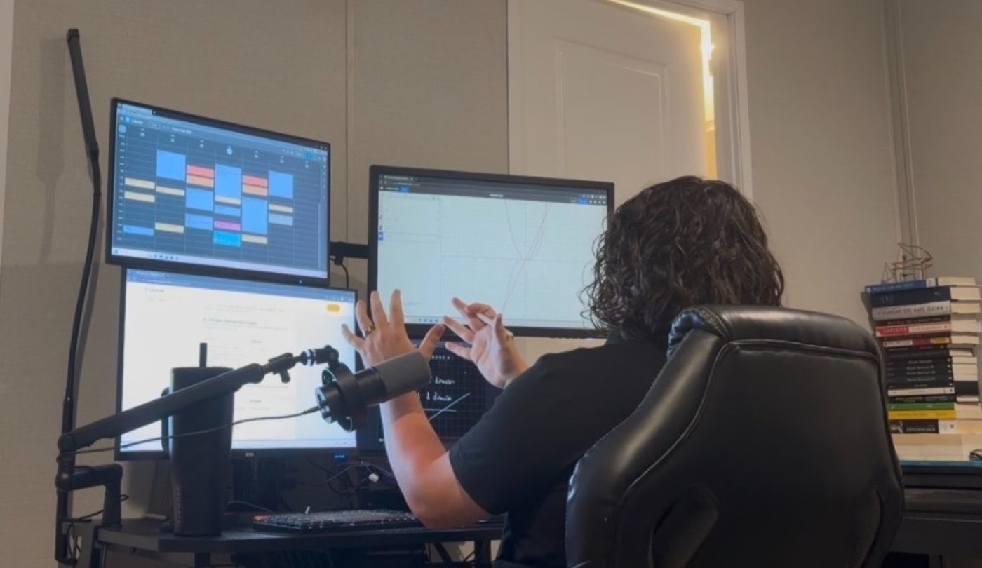 Lincoln Sheets tutoring online at his desk, gesturing toward a math graph on a multi-monitor setup with a professional microphone